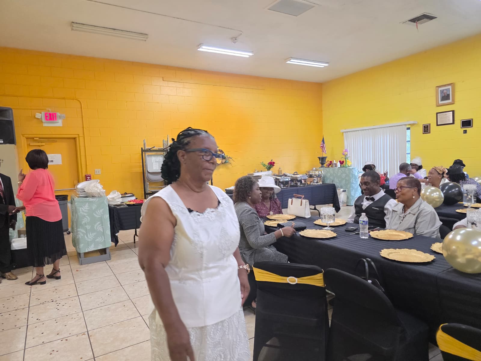 A woman standing among guests at a gathering