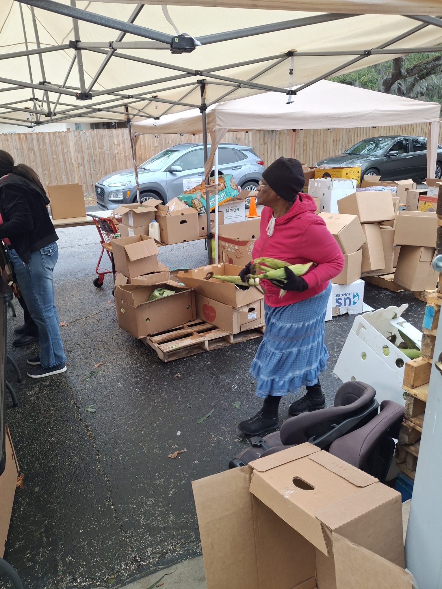 Volunteers distributing food beneath a canopy
